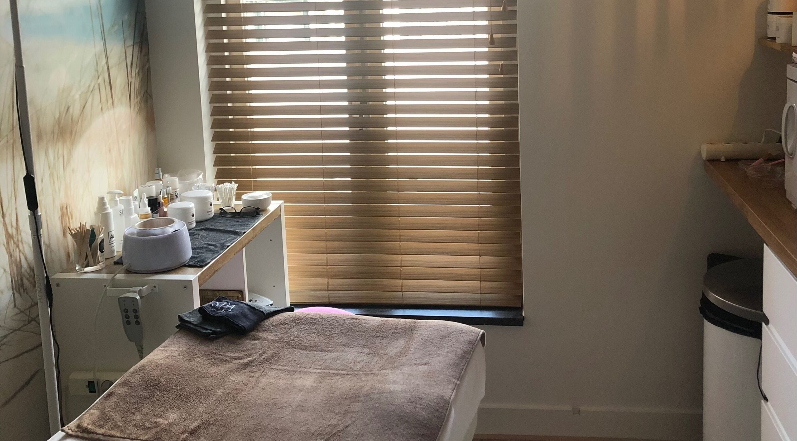 Binnenkant van Schoonheidssalon Claudia in Zandvoort, Noord-holland, NL, met wellnessproducten en behandelbed.