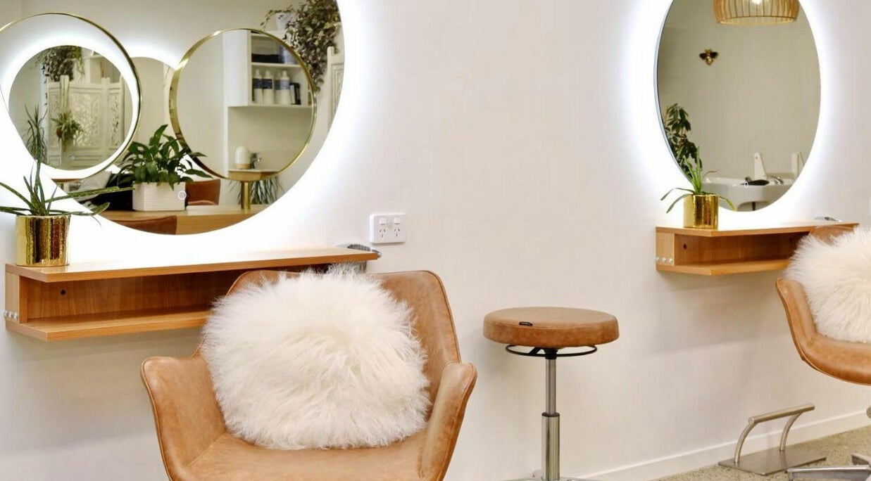Elegant salon interior at Shine Hairstylists, Kaiapoi, Canterbury, NZ, showcasing plush seating and stylish mirrors.