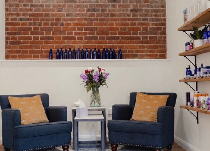 Cozy seating area at The Barn Beauty Rooms, Norwich, England, GB with stylish shelves and elegant decor.