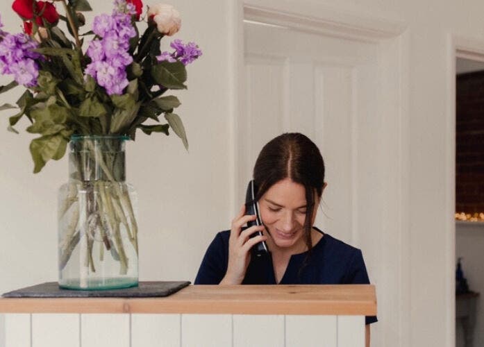Receptionist at The Barn Beauty Rooms, Norwich, England, GB with floral decor.