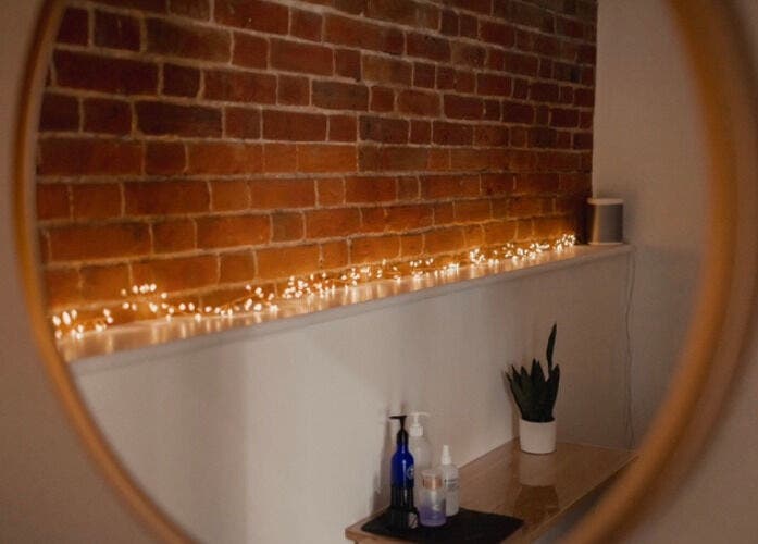 Warm ambient lighting reflected in a mirror at The Barn Beauty Rooms, Norwich, England, GB.