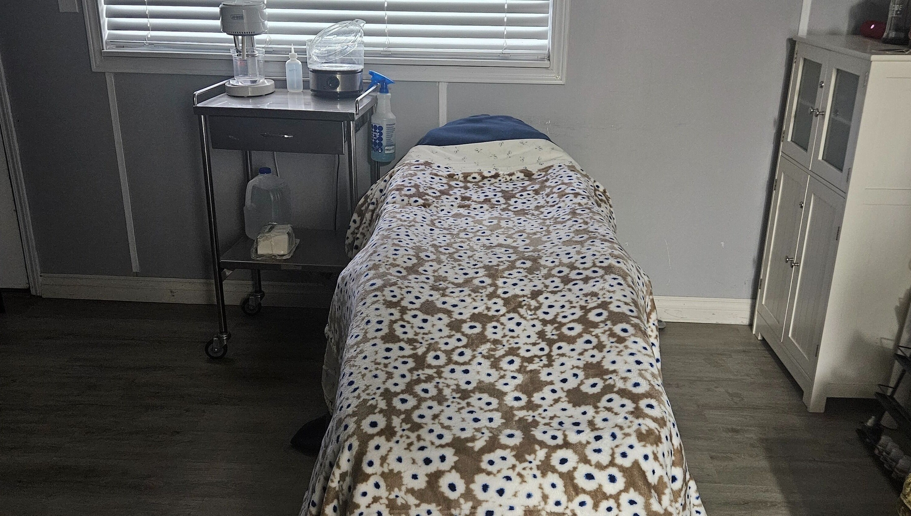 Cozy treatment room at Victoria Farris, Lewiston, Idaho, US with floral blanket on massage table.