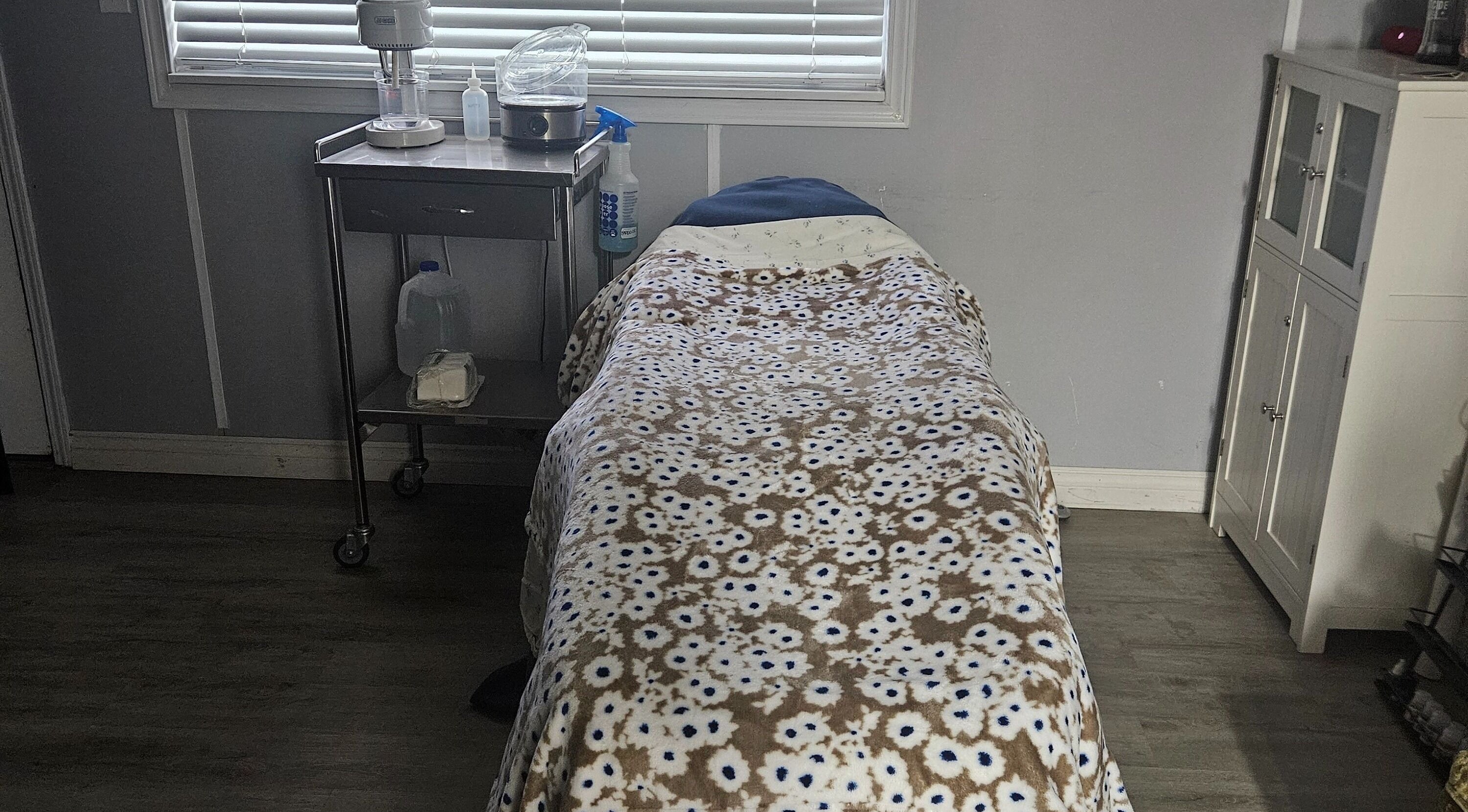 Cozy treatment room at Victoria Farris, Lewiston, Idaho, US with floral blanket on massage table.