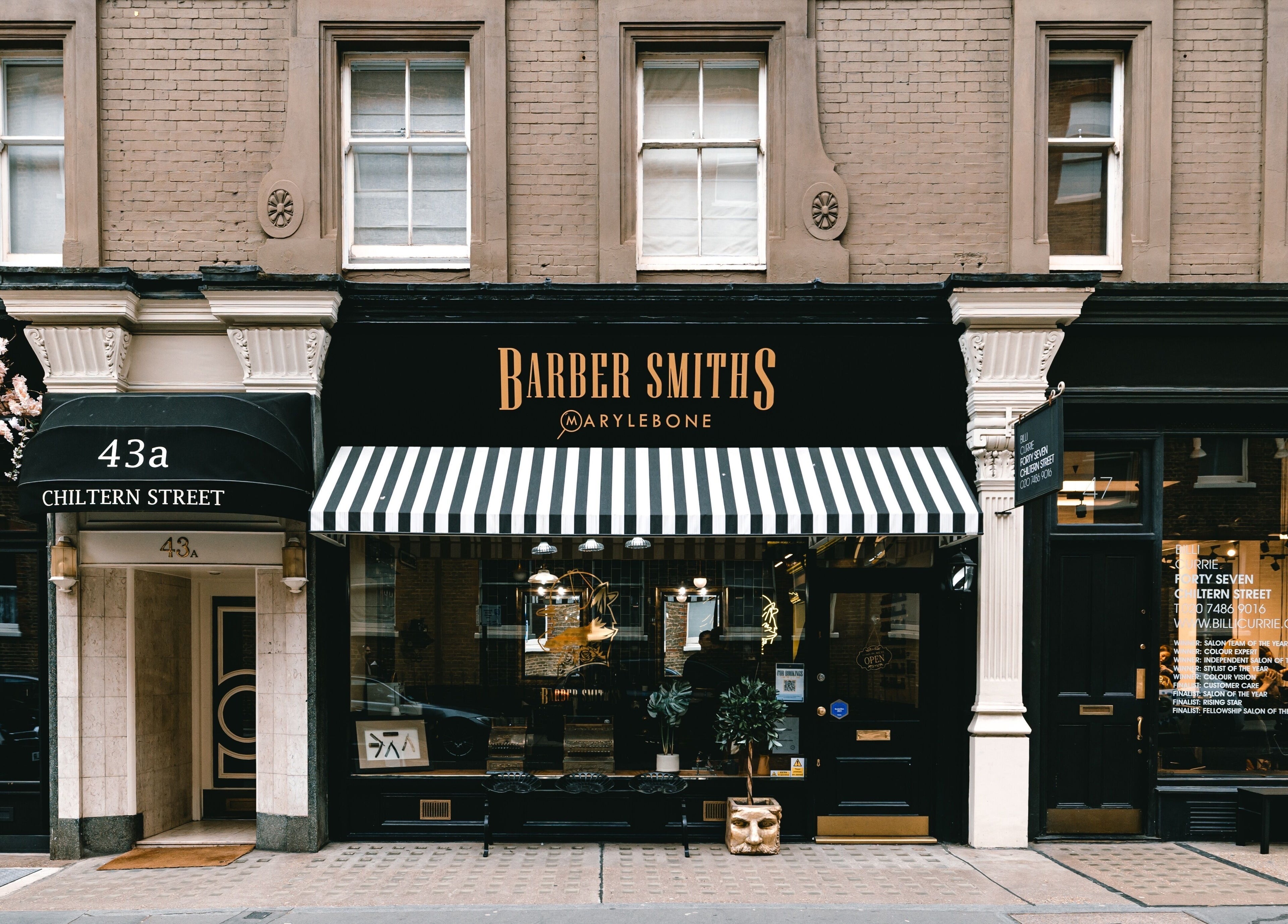 Barber Smiths Marylebone storefront on Chiltern Street, London, England, GB with stylish black and white awning.