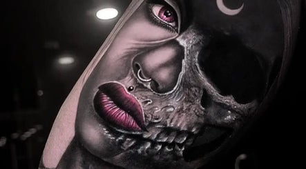 Detailed tattoo of a half-human, half-skull face at BarberSmiths Tattoo Studio, London, England, GB.