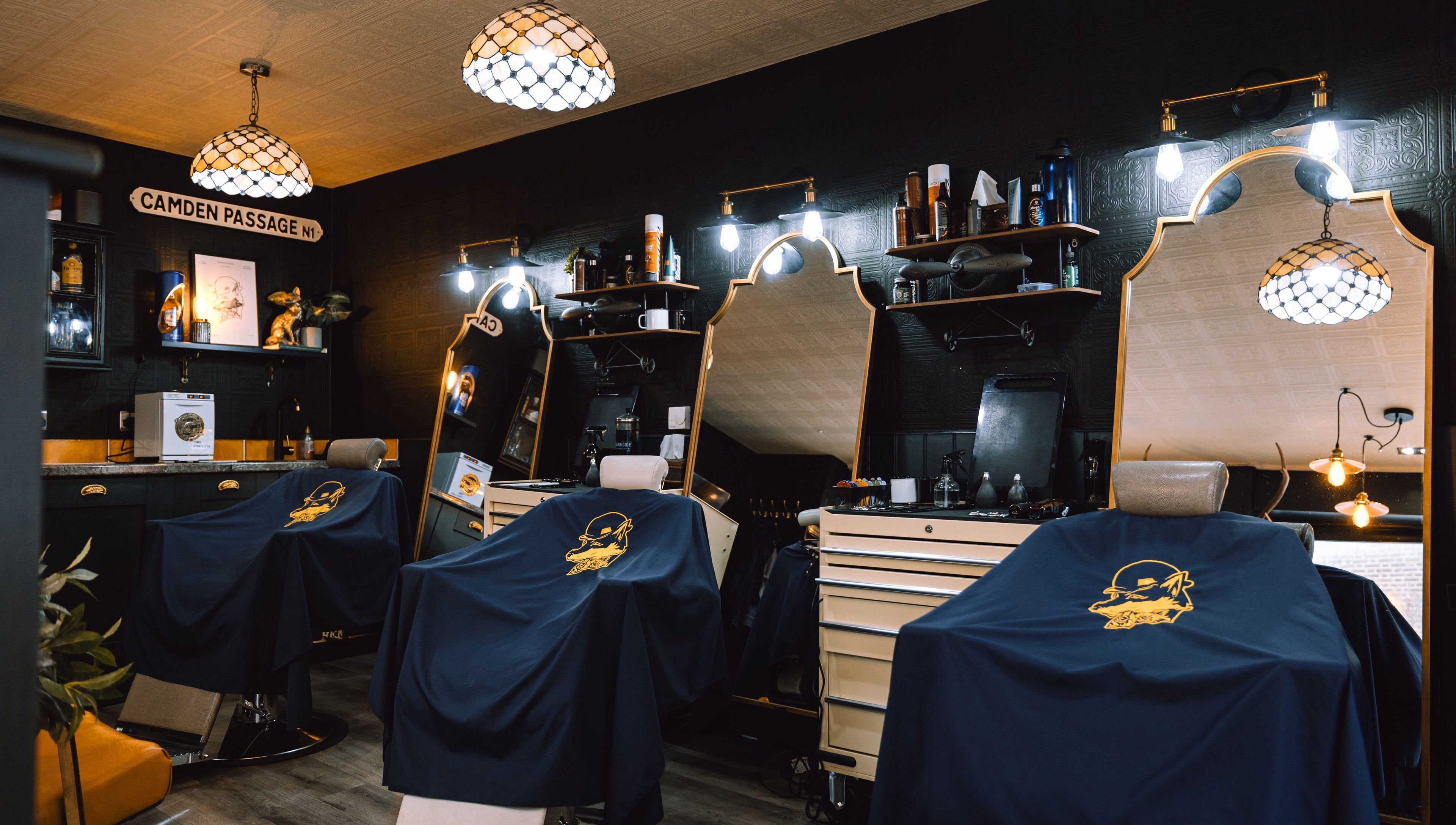 Elegant interior of BarberSmiths Islington, London, England, GB. Classic barber chairs under stylish lighting.