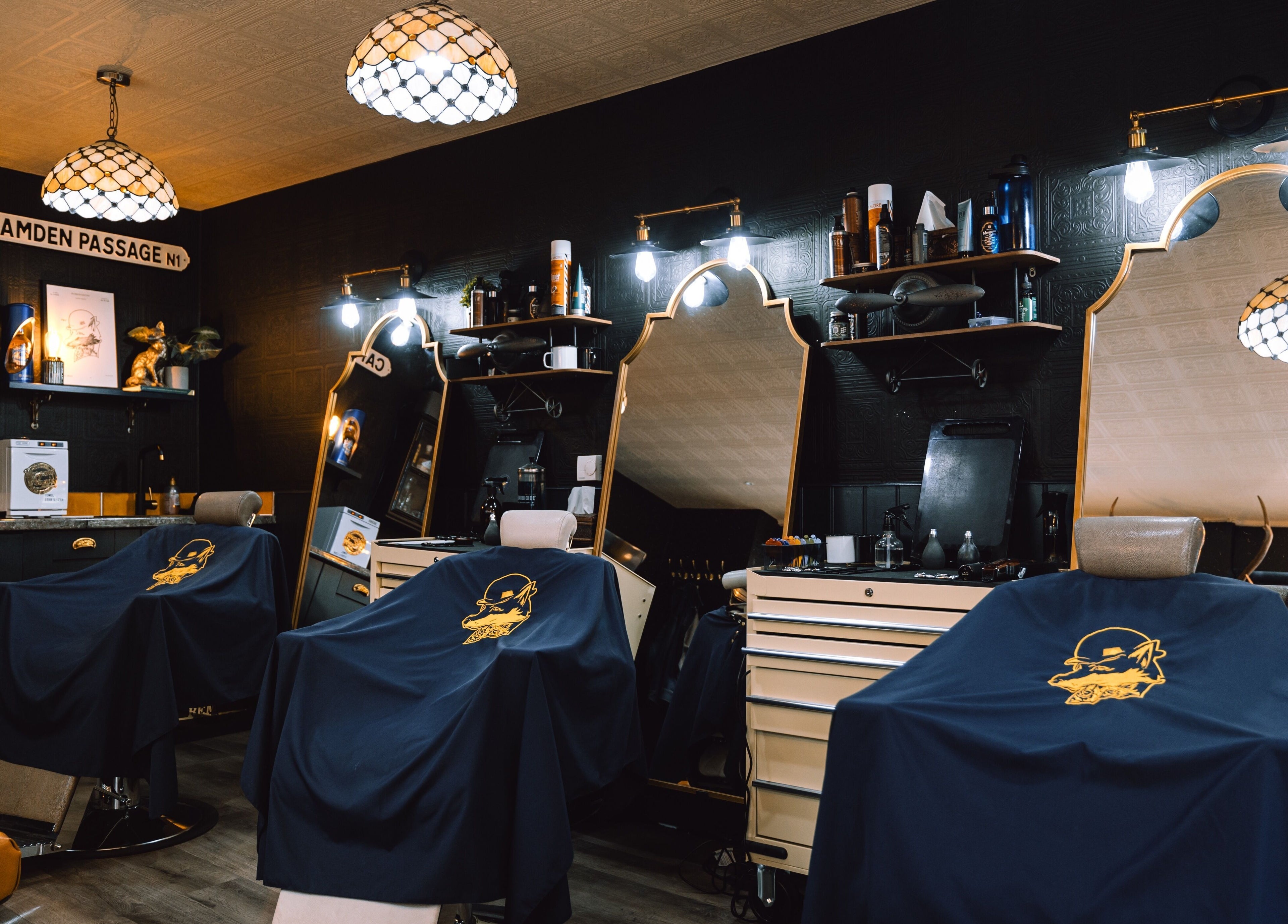 Elegant interior of BarberSmiths Islington, London, England, GB. Classic barber chairs under stylish lighting.