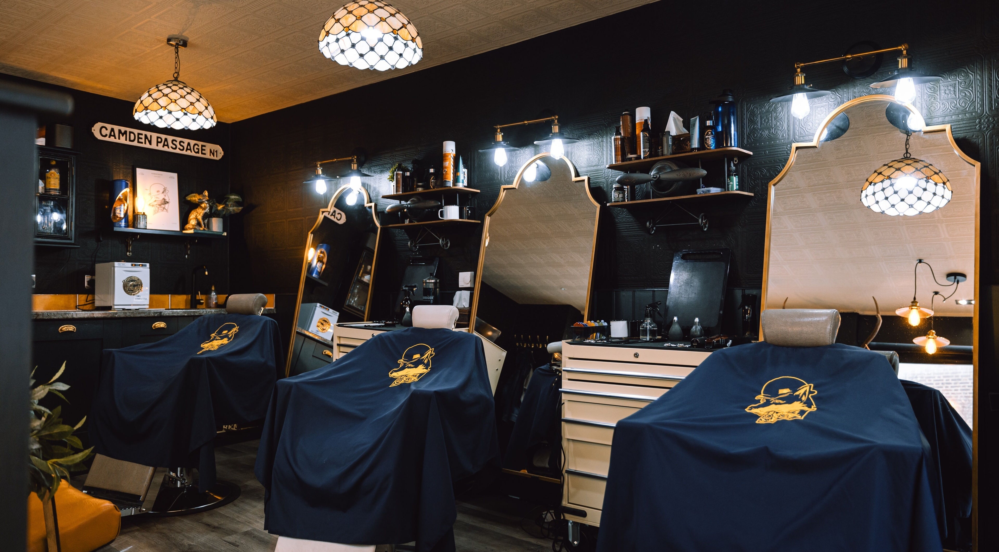 Elegant interior of BarberSmiths Islington, London, England, GB. Classic barber chairs under stylish lighting.
