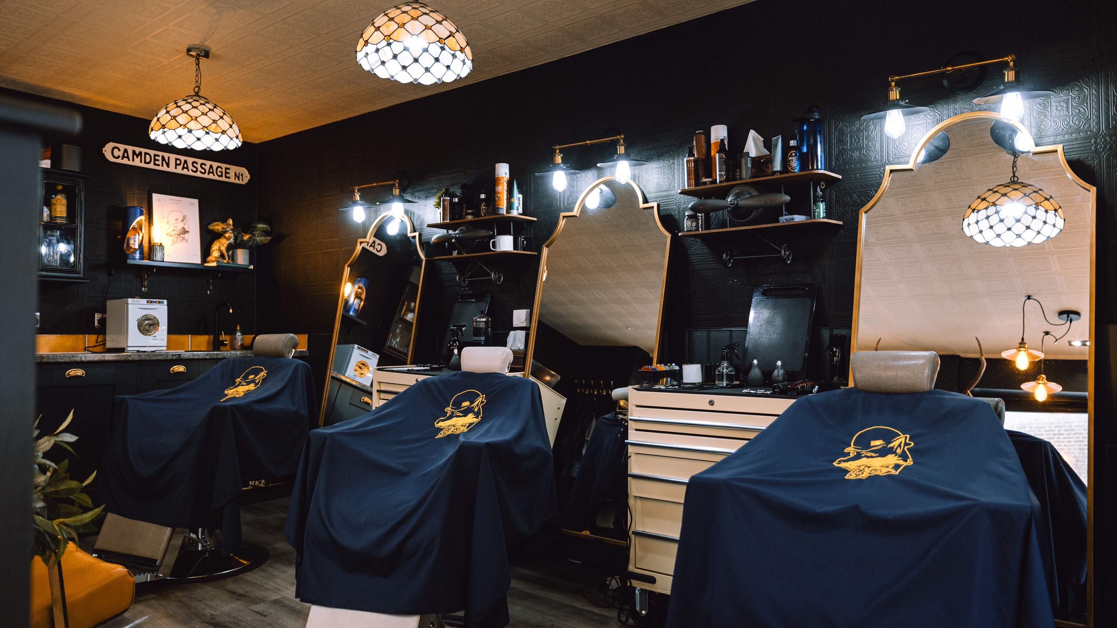 Elegant interior of BarberSmiths Islington, London, England, GB. Classic barber chairs under stylish lighting.