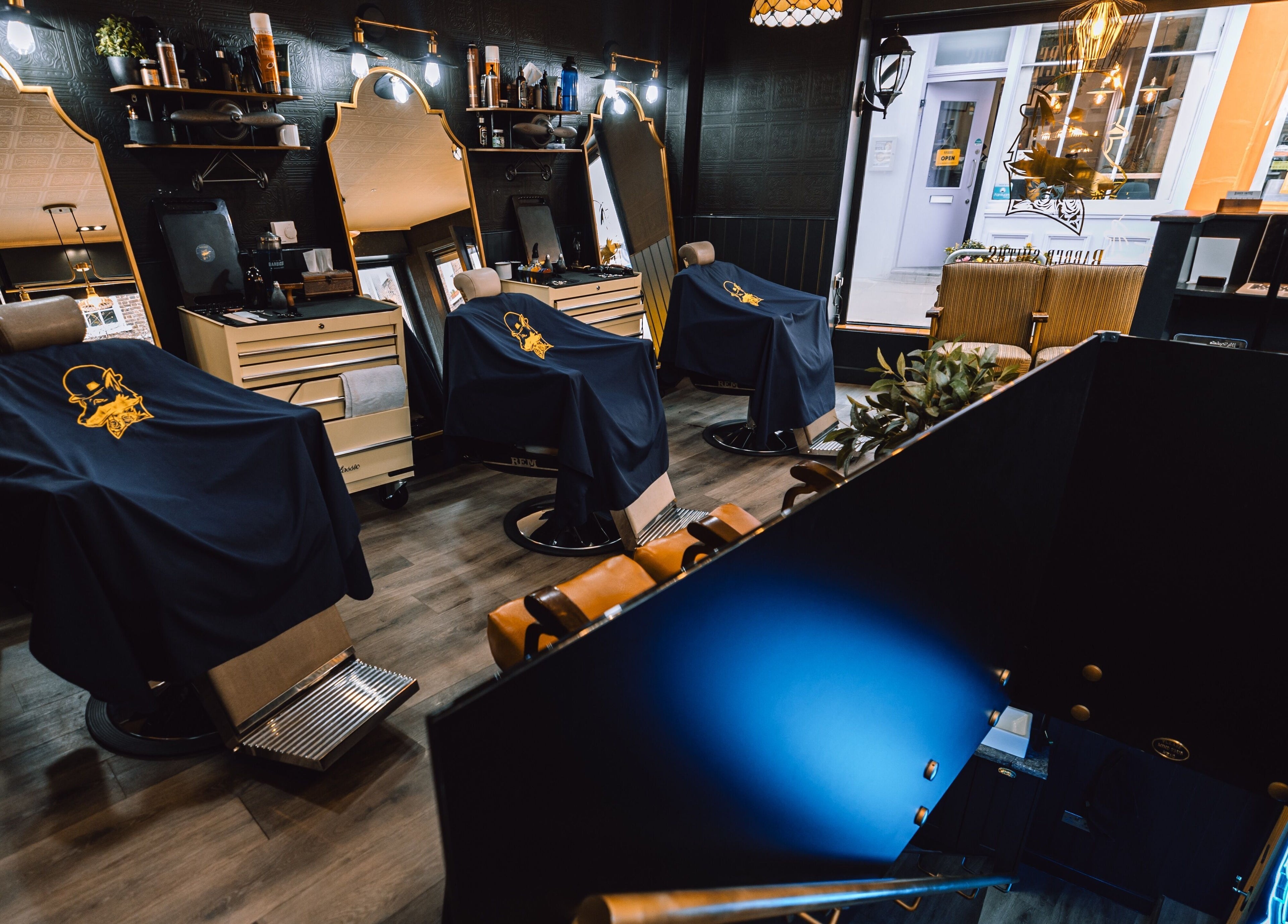 Stylish interior of BarberSmiths Islington in London, England, GB with modern barber chairs and mirrors.