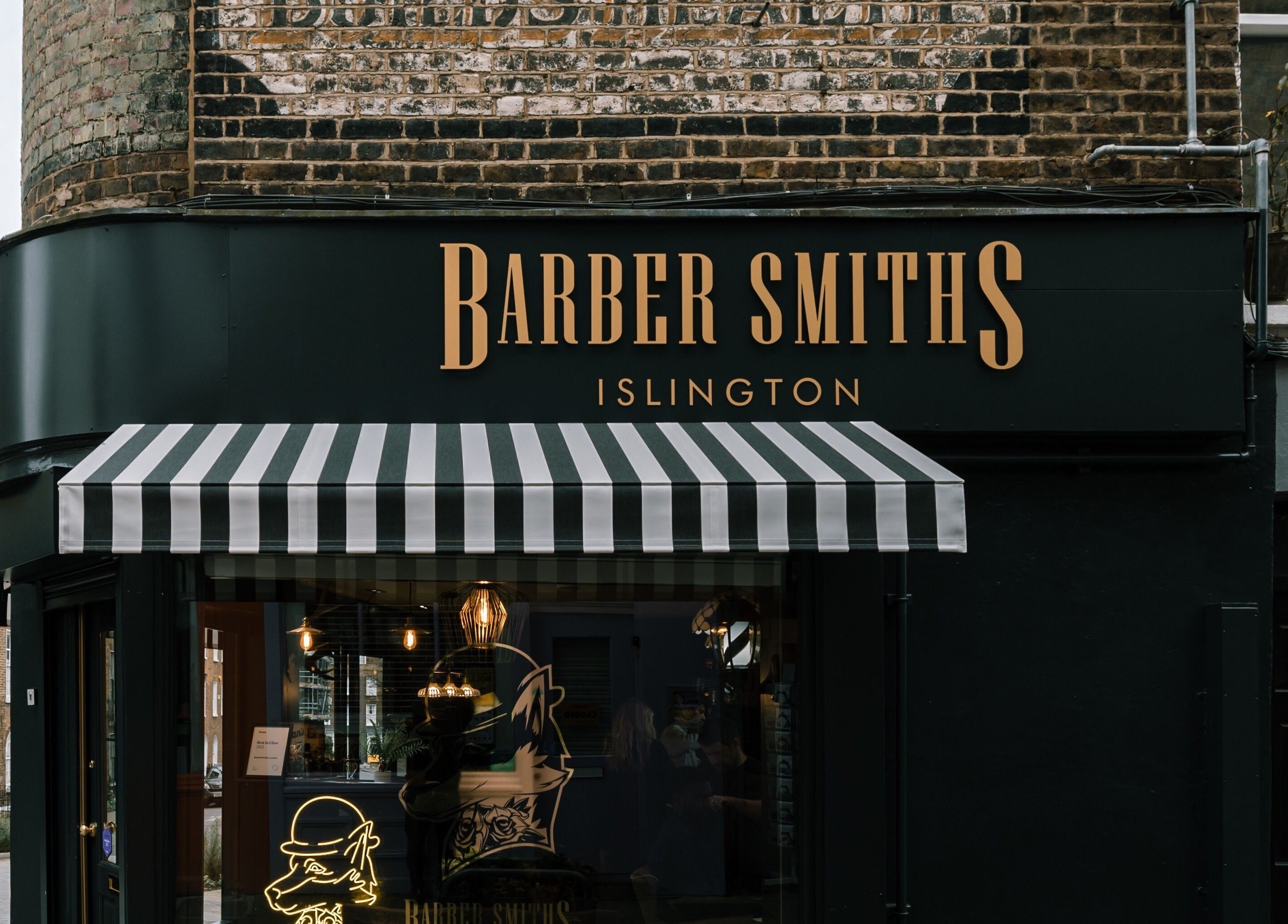 Front view of BarberSmiths Islington with striped awning in London, England, GB.