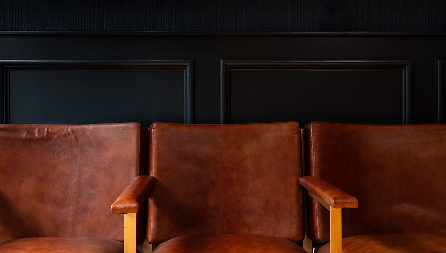 Warm brown leather chairs at BarberSmiths Notting Hill in London, England, GB, offer a stylish waiting area.