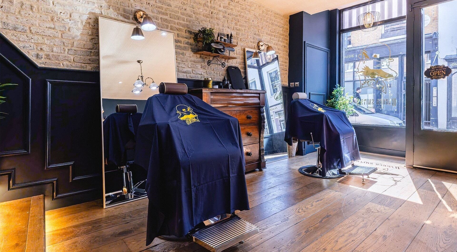 Chic interior of BarberSmiths Richmond, showcasing barber chairs and brick walls in Richmond, England, GB.