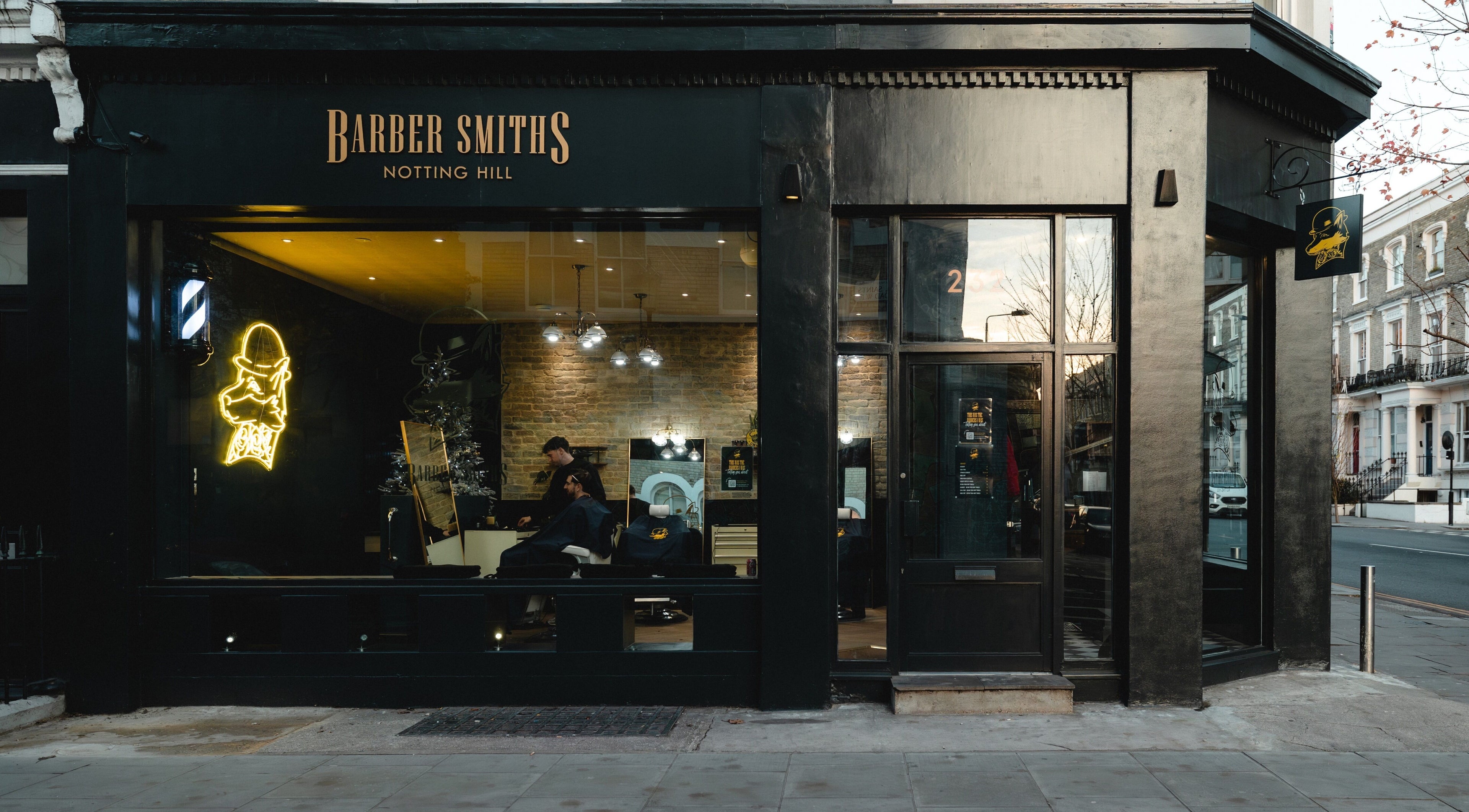 Exterior of BarberSmiths Notting Hill, a chic barbershop in London, England, GB with a neon sign.