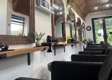 Elegant salon interior at The Hair Exchange, Blunham, England, GB, showcasing mirrors and styling stations.