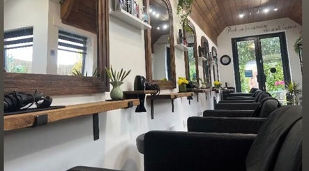 Elegant salon interior at The Hair Exchange, Blunham, England, GB, showcasing mirrors and styling stations.