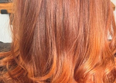 Vibrant orange balayage hairstyle at The Hair Exchange, Blunham, England, GB. Perfect blend of curls and color.