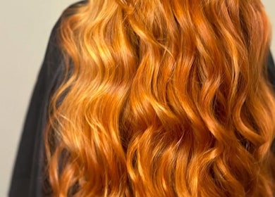 Vibrant red hair in soft waves at The Hair Exchange, Blunham, England, GB.