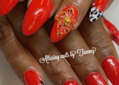 Elegant red nails with floral art by Alluring Nails by Tammy in New Providence, BS.
