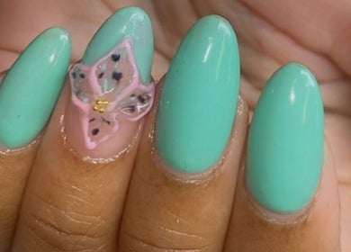 A vibrant aqua manicure with floral accent design at Alluring Nails by Tammy, New Providence, BS.
