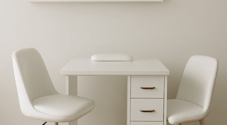 Elegant nail station at Alluring Nails by Tammy, New Providence, BS, featuring plush white chairs and sleek design.