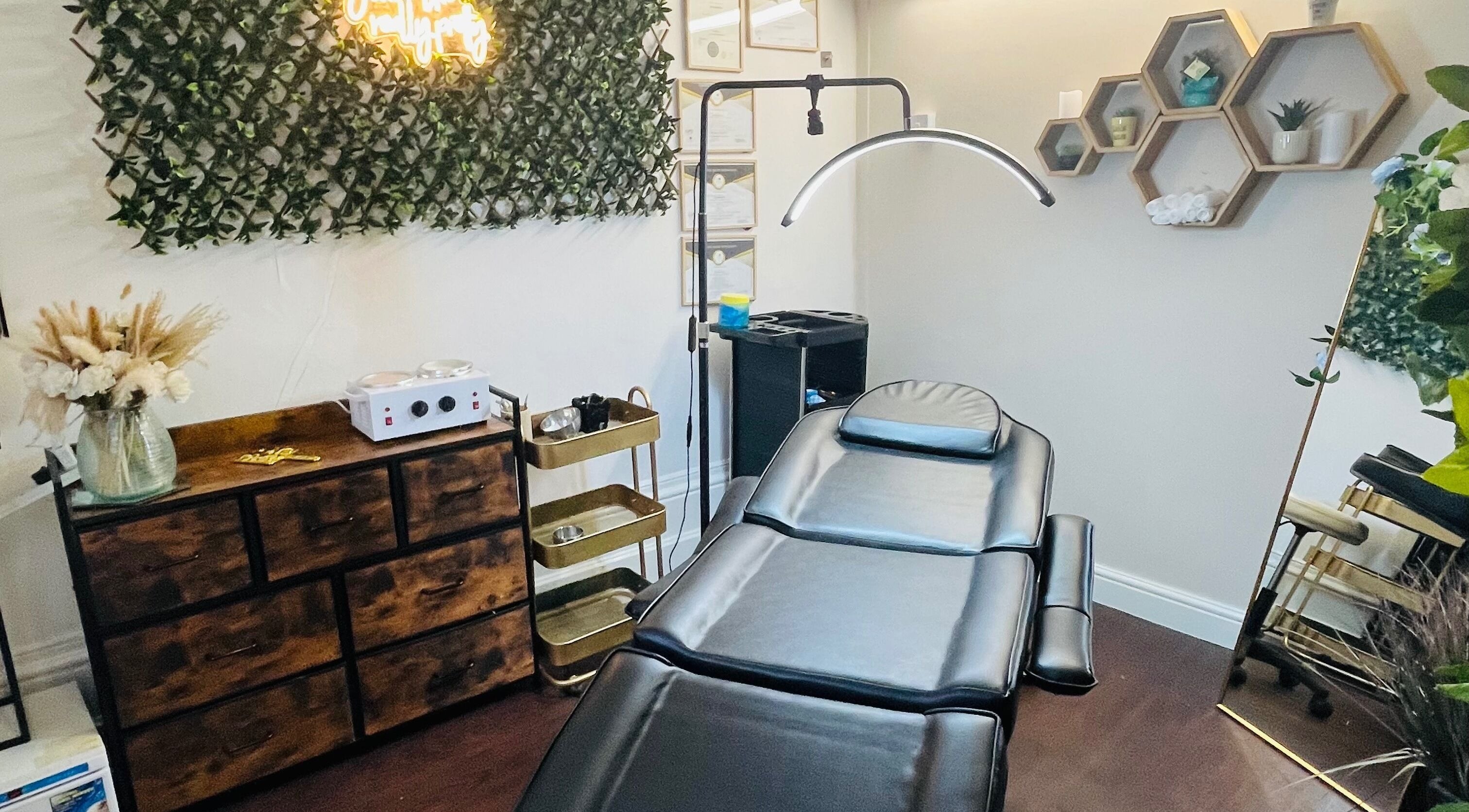 Relaxing spa room at Glamour’Us Nails and Beauty, Derby, England, GB, features a sleek black chair and natural decor.