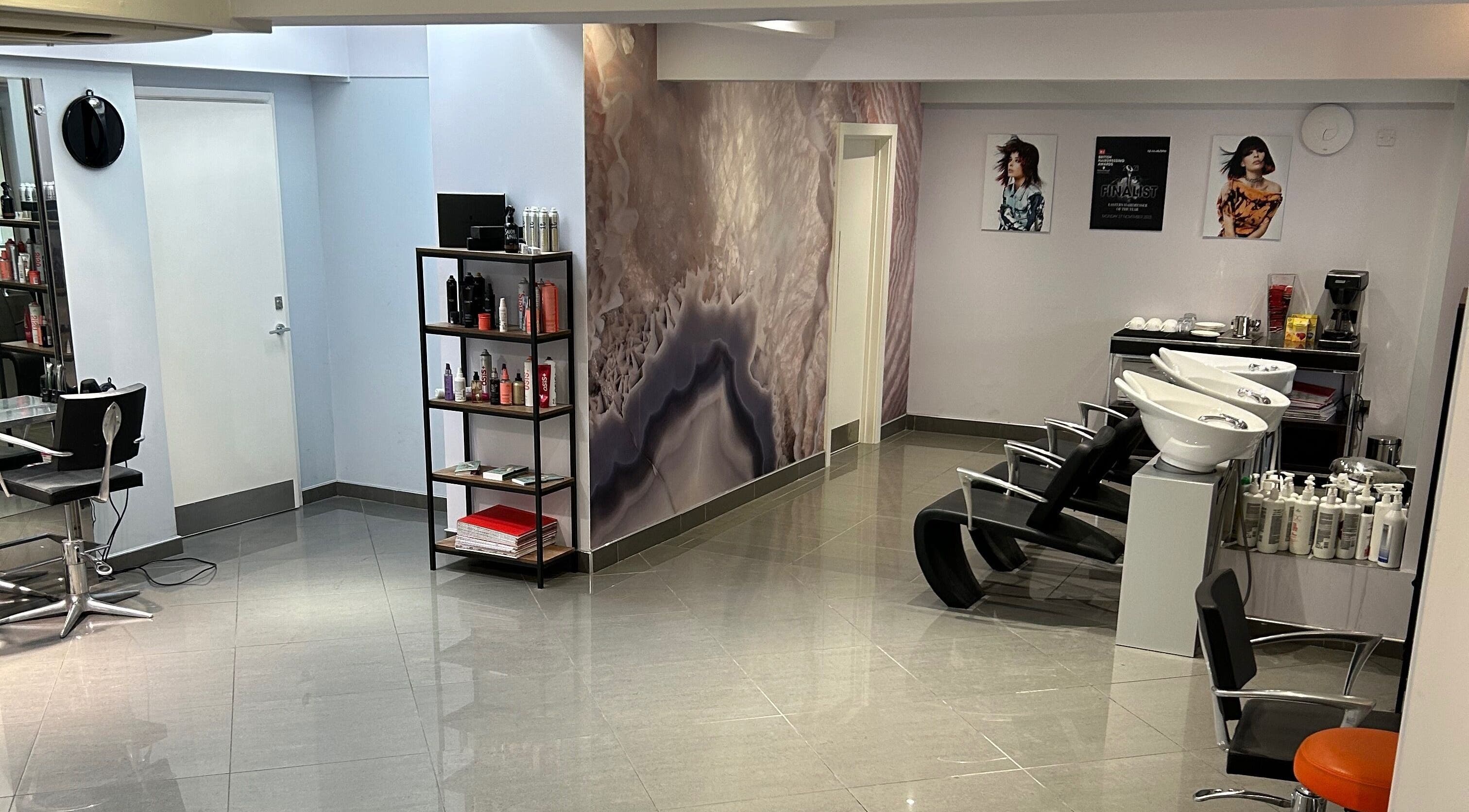 Modern interior of Antonio Giovanni Hairdressing Friars Street, Ipswich, England, GB with sleek chairs and products.