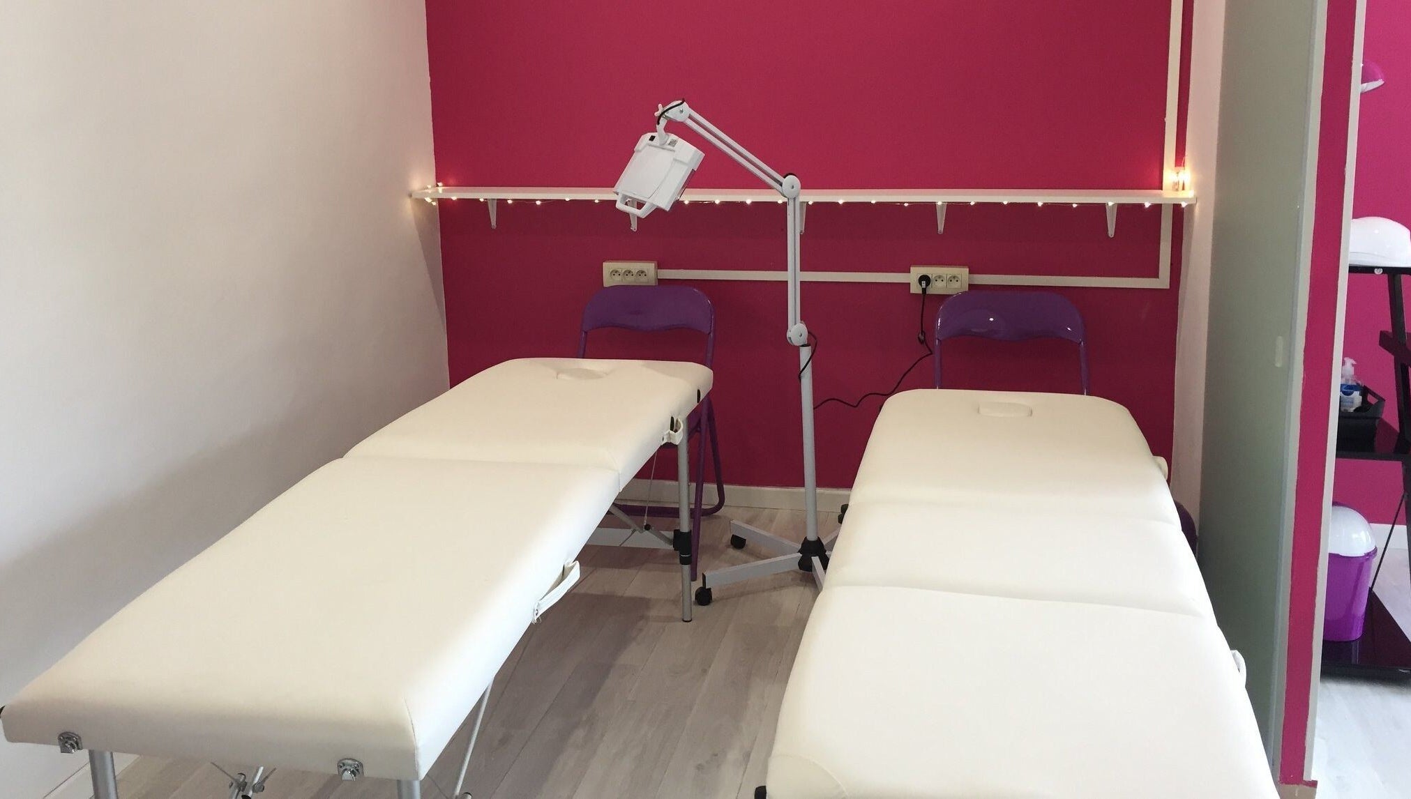 Salle de massage moderne à Vermeille Formation, Canet-en-Roussillon, Occitanie, FR avec murs roses et tables blanches.