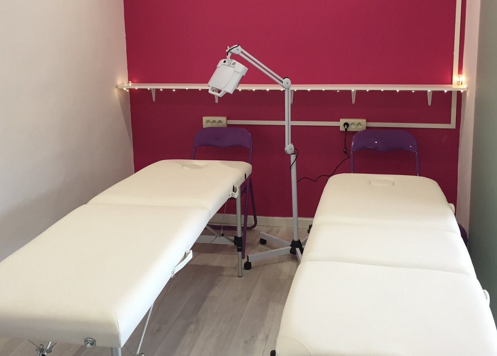 Salle de massage moderne à Vermeille Formation, Canet-en-Roussillon, Occitanie, FR avec murs roses et tables blanches.