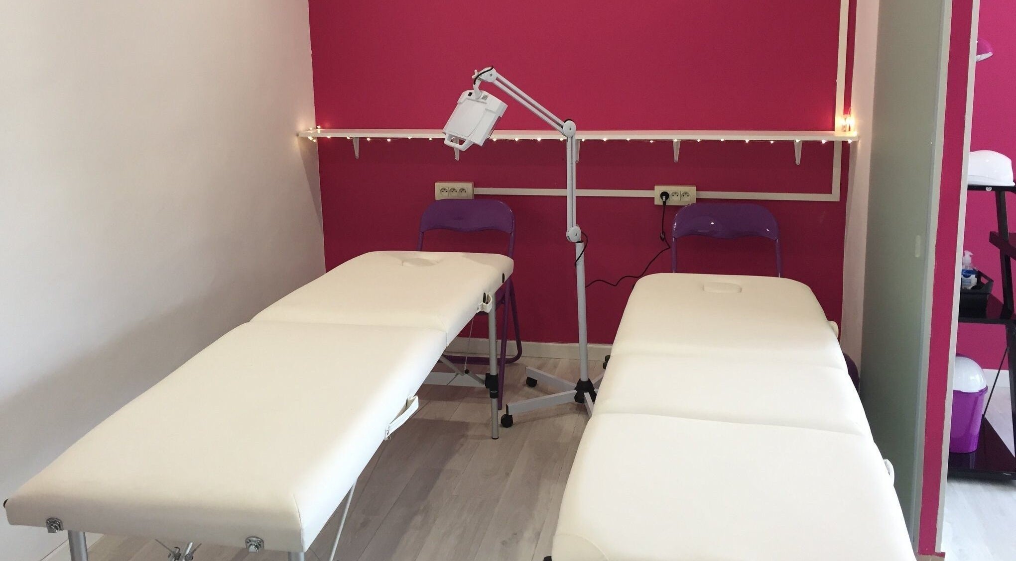 Salle de massage moderne à Vermeille Formation, Canet-en-Roussillon, Occitanie, FR avec murs roses et tables blanches.