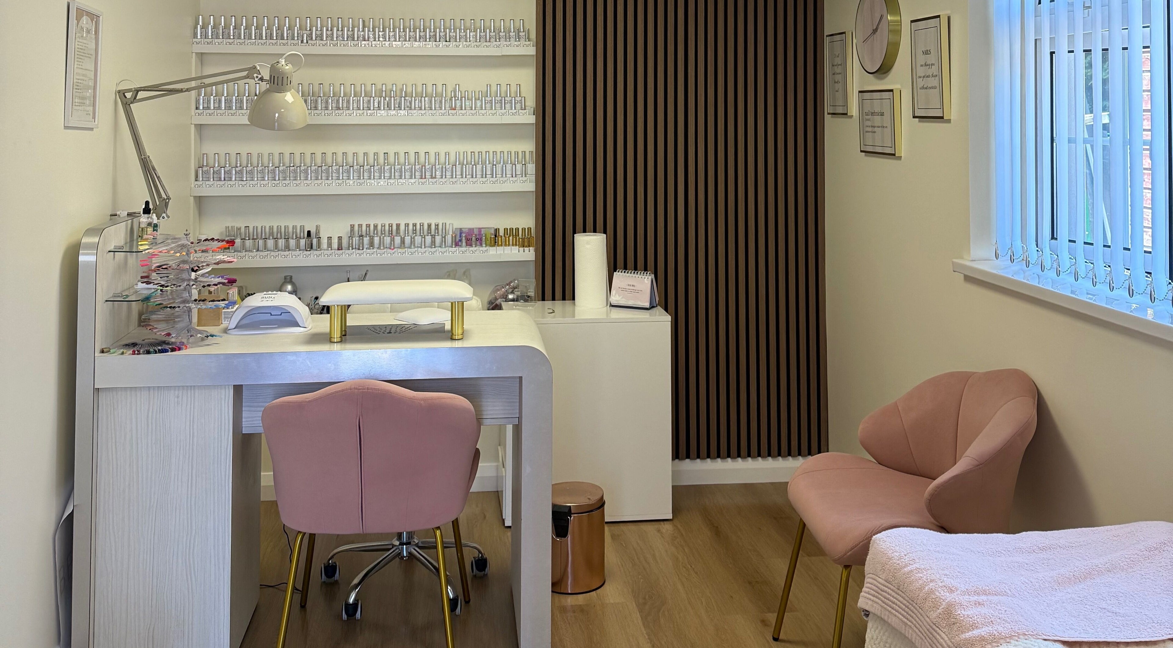 Elegant nail station at Beauty 82, Coalisland, Northern Ireland, GB, with pink chairs and nail polish display.