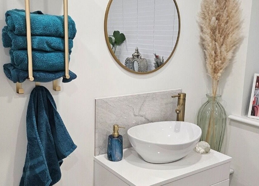 Chic restroom decor at Perfect Touch Nail Bar, New Mills, England, GB features blue towels and golden fixtures.