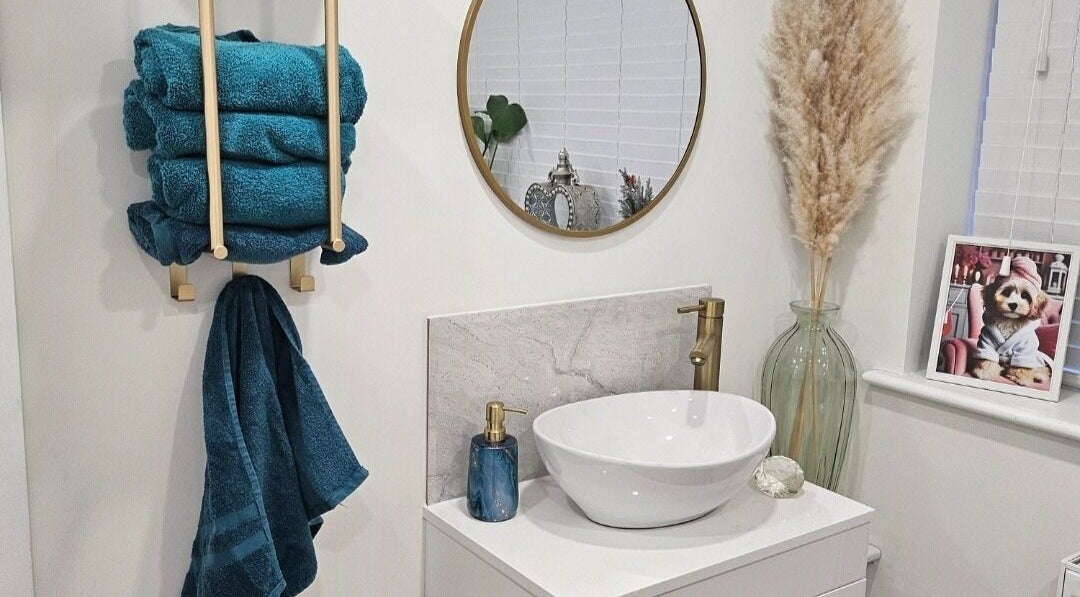 Chic restroom decor at Perfect Touch Nail Bar, New Mills, England, GB features blue towels and golden fixtures.