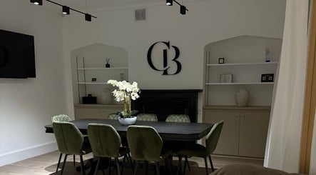 Chic meeting area at Curlita Beauty & Skin Clinic, Stafford, England, GB with green chairs and decor.