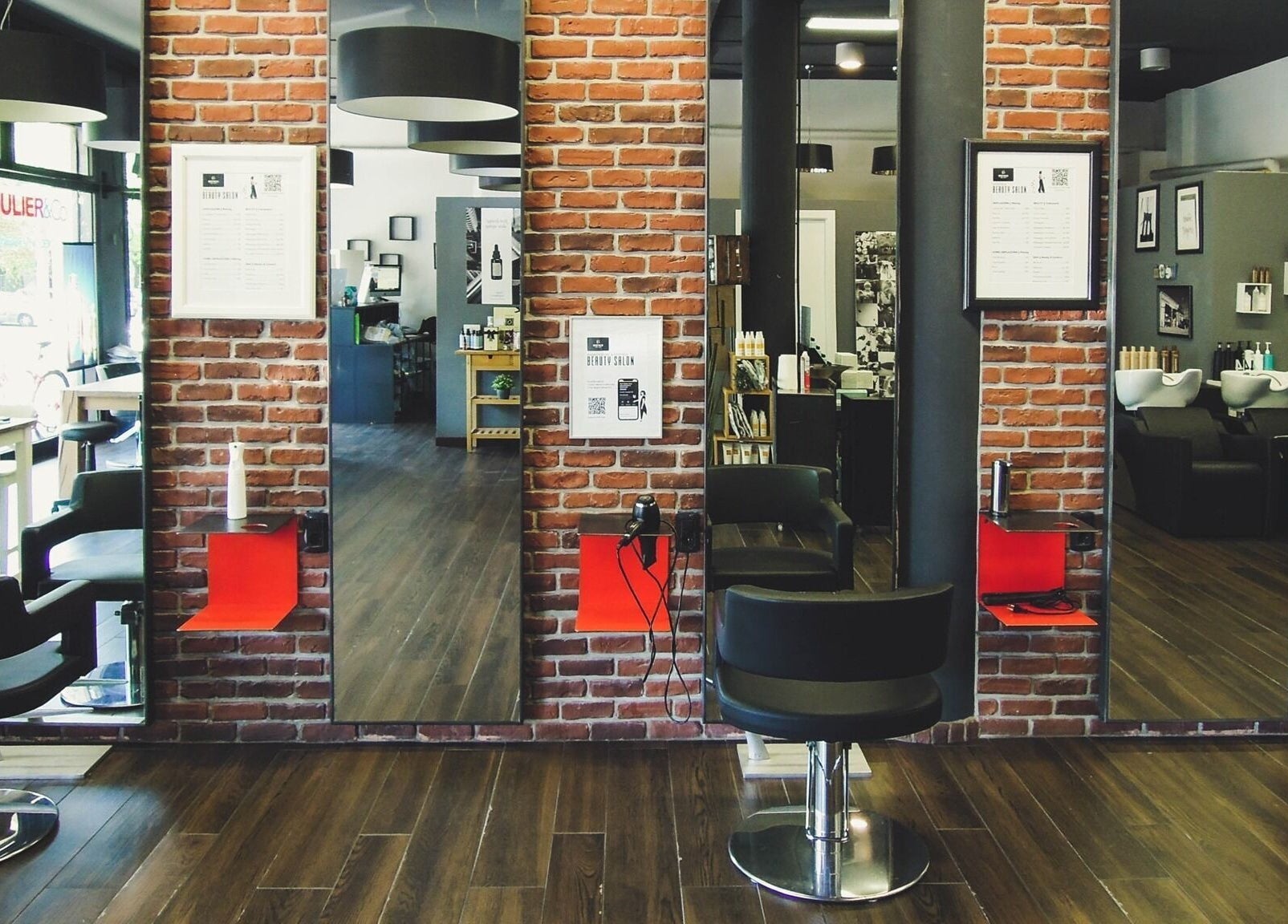 Interno di Anthea Mulier - Hair & Beauty a Corsico, Lombardia, IT con mattoni a vista e sedie da parrucchiere.