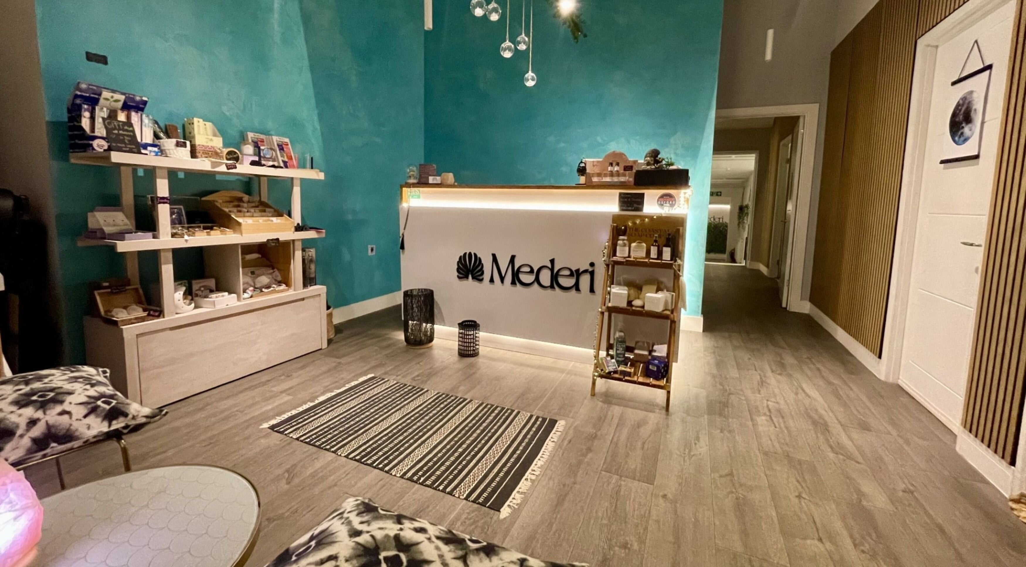 Mederi Wellness reception area in Garsington, England, GB, featuring a calming teal wall and serene decor.