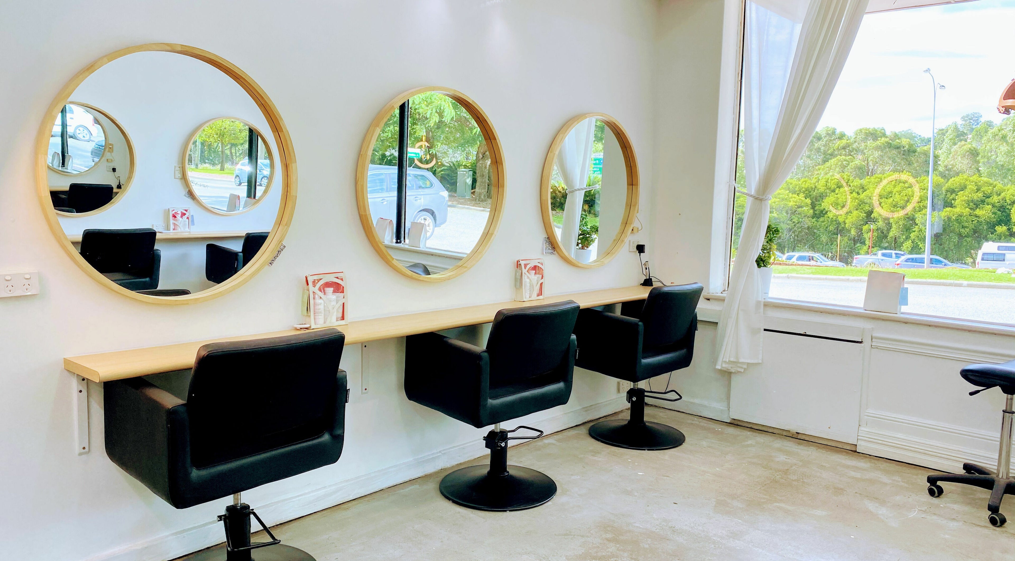 Modern salon seating at Room for Hair, Armadale, Western Australia, AU with stylish round mirrors and natural light.