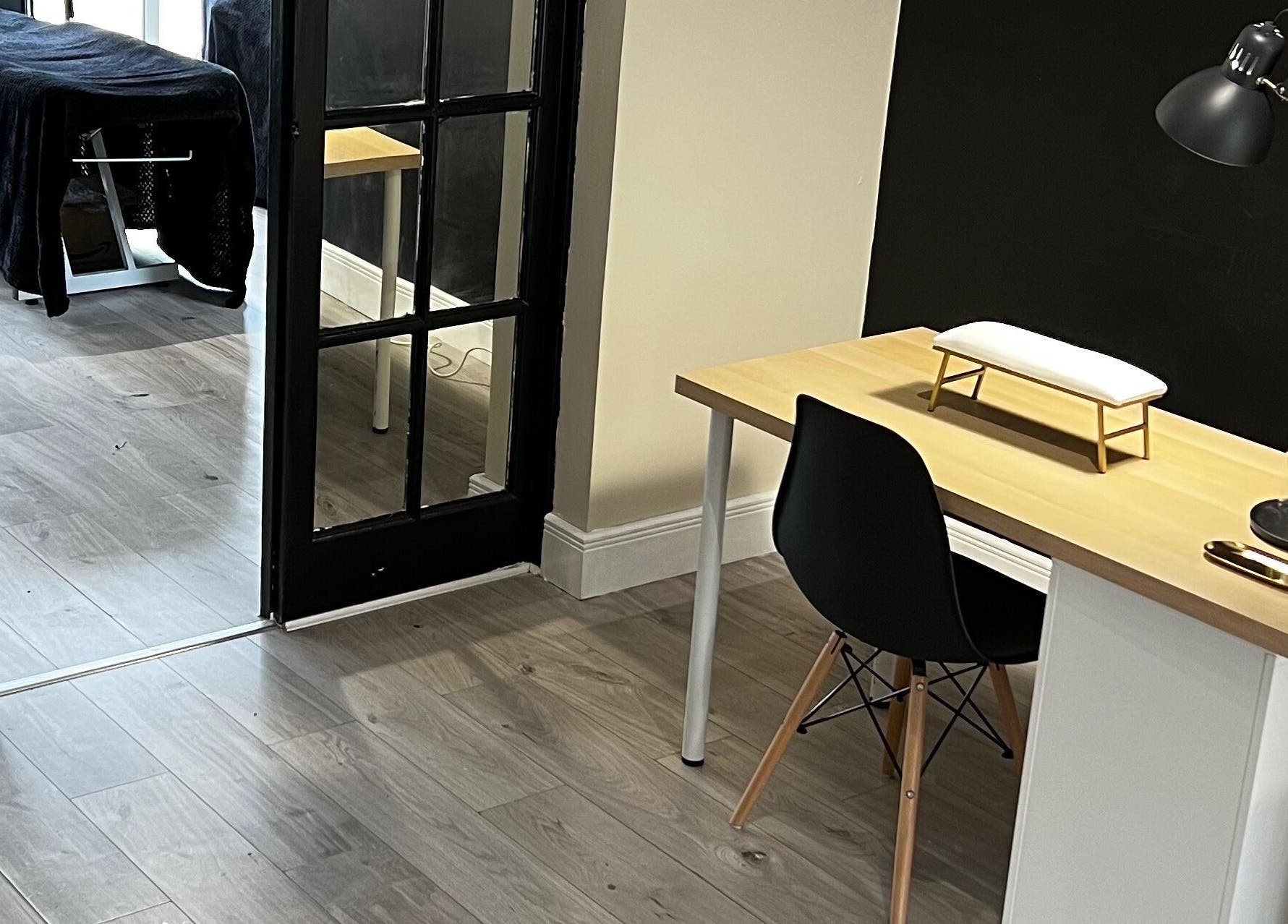 Modern beauty setup at Studio Glow, Huddersfield, England, GB. Cozy desk area with treatment table in view.