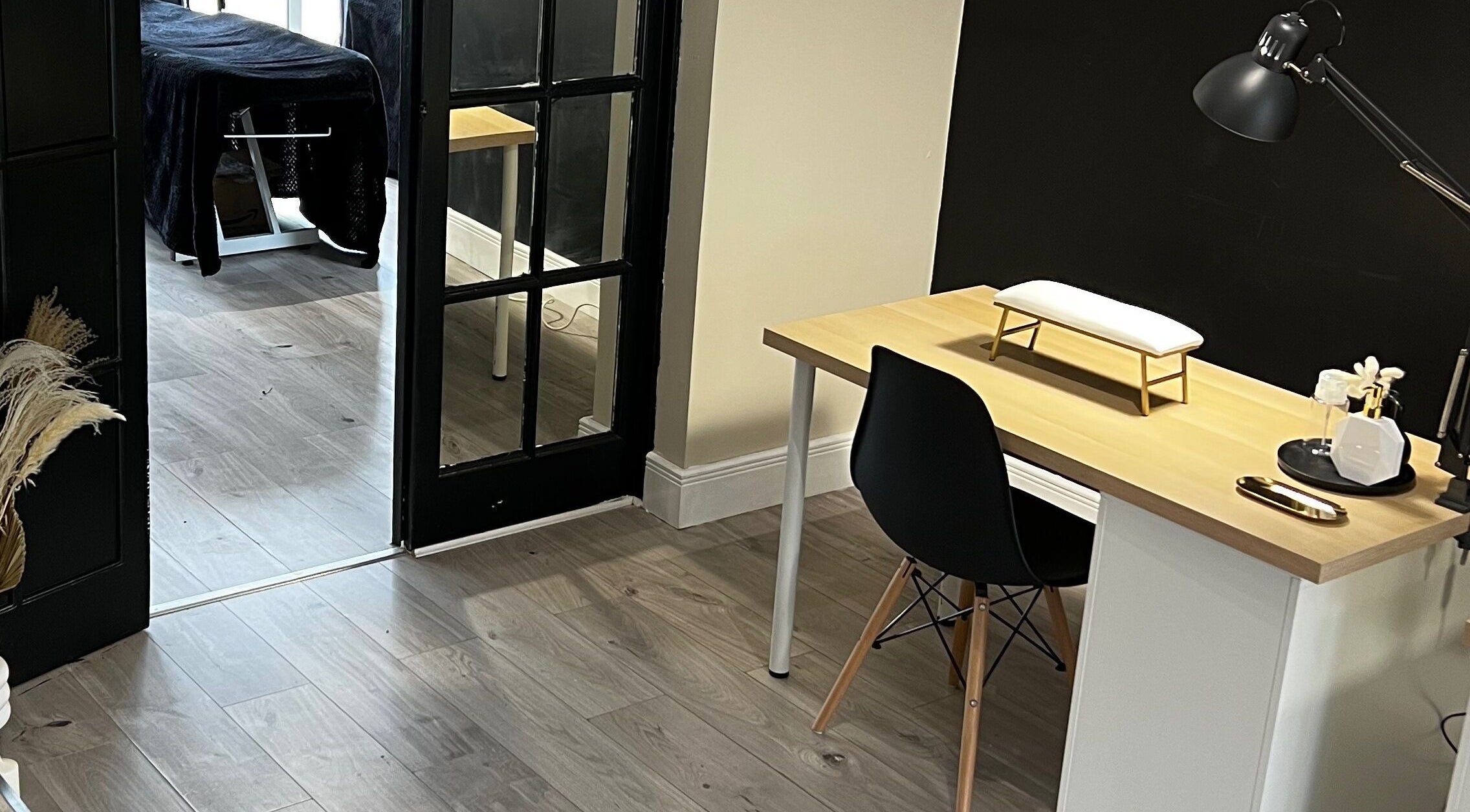 Modern beauty setup at Studio Glow, Huddersfield, England, GB. Cozy desk area with treatment table in view.