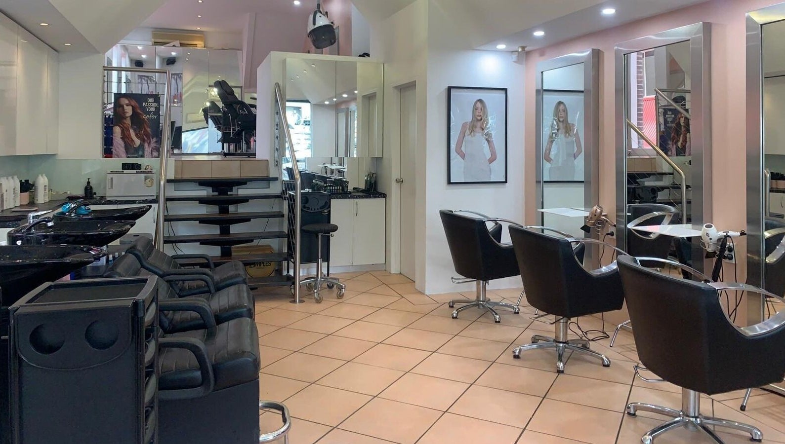 Modern interior of The Edge Hair Salon in Wahroonga, New South Wales, AU with stylish chairs and mirrors.