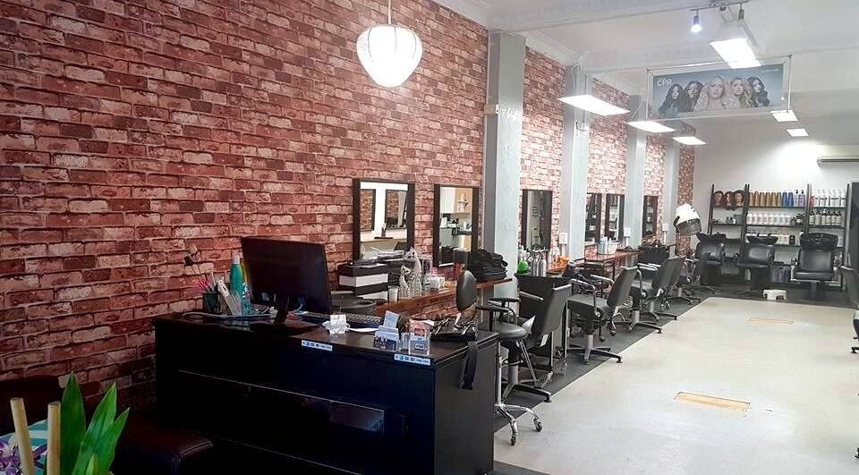 Interior of Top Katz salon in Wynnum, Queensland, AU featuring styling stations against a brick wall.