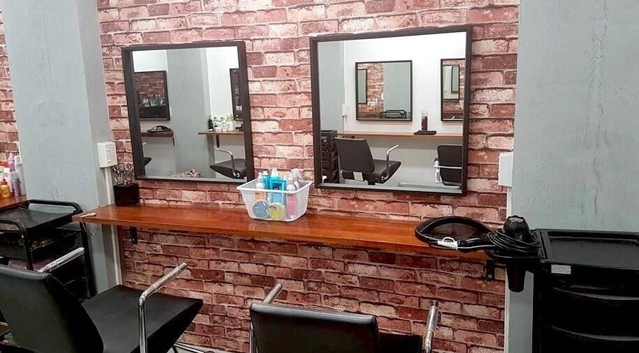 Stylish salon interior at Top Katz, Wynnum, Queensland, AU with brick walls and chic mirrors.
