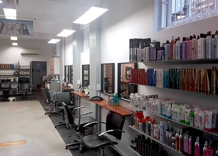 Modern salon interior at Top Katz, Wynnum, Queensland, AU showcasing elegant styling stations and product displays.