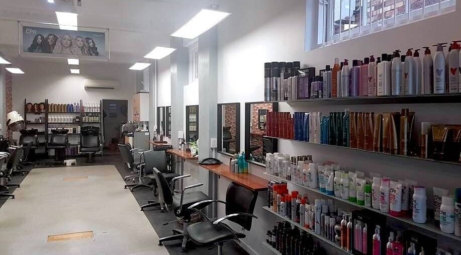 Modern salon interior at Top Katz, Wynnum, Queensland, AU showcasing elegant styling stations and product displays.