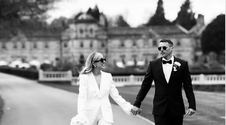 A stylish couple in formal attire walking outdoors, emphasizing elegance at Steph Skelton Hair Studio, York, England, GB.