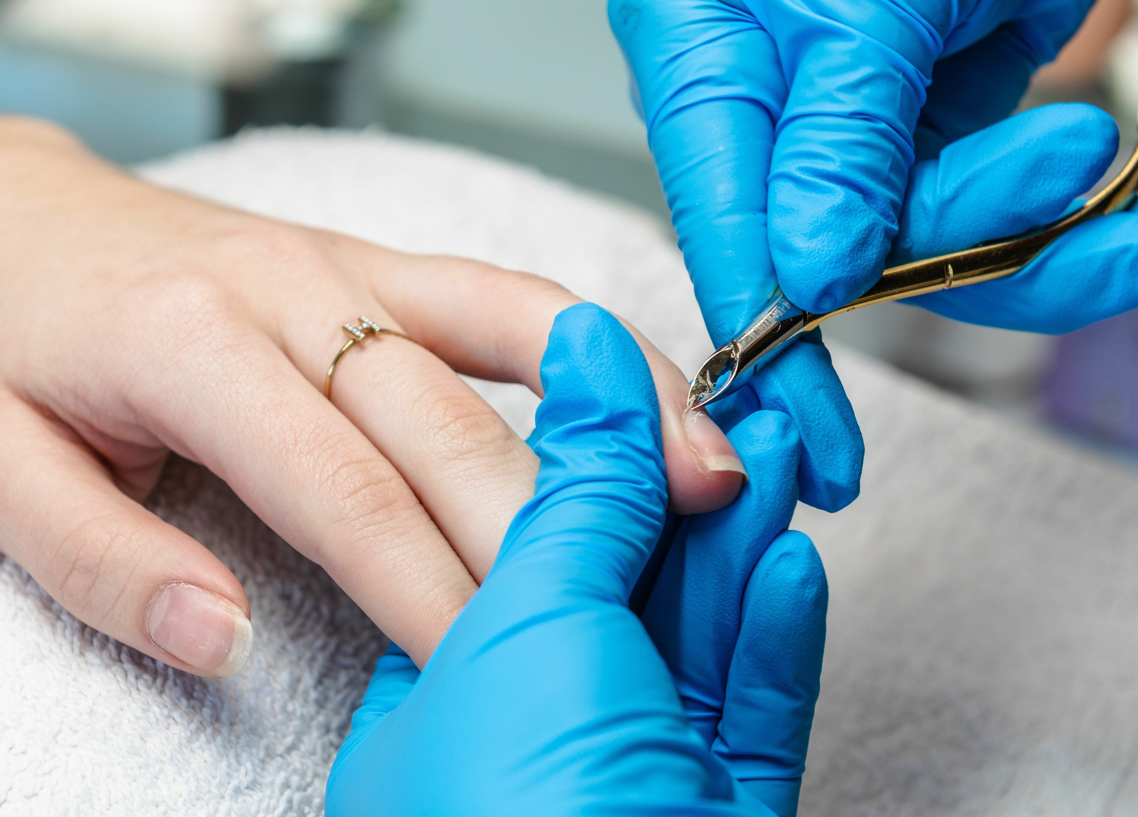 Nail care at Spring Hair and Nails Salon, Regina, Saskatchewan, CA. Expert trimming in progress.