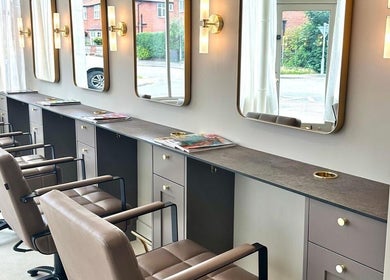 Modern salon chairs and mirrors at Cavell & Co., Norwich, England, GB, showcasing elegant interior design.