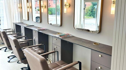 Modern salon chairs and mirrors at Cavell & Co., Norwich, England, GB, showcasing elegant interior design.