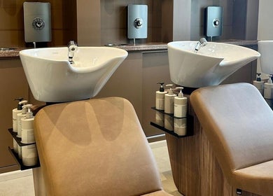 Elegant wash stations at Cavell & Co., Norwich, England, GB, featuring modern sinks and comfortable seating.