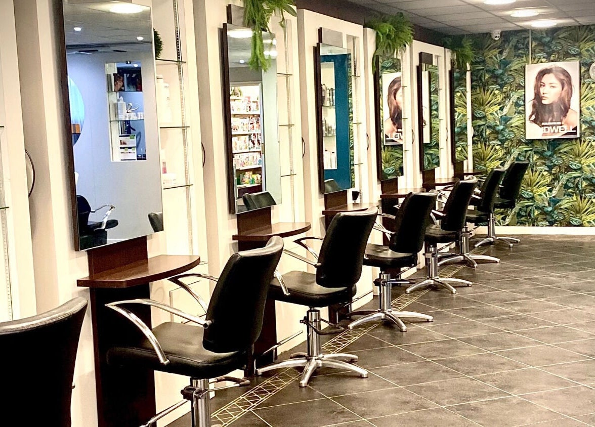 Modern salon interior at hairstyles@wetherells, Selby, England, GB with sleek chairs and vibrant decor.